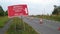 Works access only sign next to roadworks cones flashing on UK motorway at evening with traffic passing