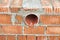 Works on the laying of ceramic bricks. Red brick wall with ventilation hole. Embedded detail in the wall. Progressive construction