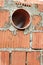 Works on the laying of ceramic bricks. Red brick wall with ventilation hole. Embedded detail in the wall. Progressive construction