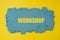 Workshop word written on yellow background with blue kinetic sand. Business Concept