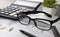 Workspace with calculator, pen, glasses and notebook. Financial data, analysis of handwritten letter, office on the table.