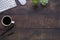 Workspace in office with wood table. Top view from above of keyboard with notebook and coffee. Desk for modern creative work of de