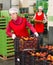 Workwoman carrying plastic box with peaches