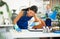 Workwoman of cleaning service wiping dust on furniture in office