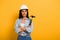 Workwoman in helmet holding hammer with