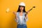Workwoman in helmet holding hammer and