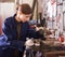 Workwoman shaping metal parts in workshop