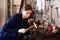 Workwoman shaping metal parts in workshop