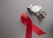 World AIDS day, red ribbon and men's WRISTWATCH on grey background, top view. solidarity in the fight against the disease