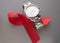 World AIDS day, red ribbon and men's WRISTWATCH on grey background, top view. solidarity in the fight against the disease