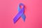 World Arthritis Day. Blue and purple awareness ribbon on pink background, top view
