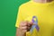 World Arthritis Day. Woman with blue and purple awareness ribbon on green background, closeup