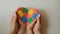 World Autism Awareness Day. Adults and a child hold a heart decorated with colorful puzzle pieces in their hands.