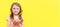 World Donut Day or No diet day. A little girl holding donuts and smiling, holding on a yellow background. The concept. kids and