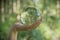 World environmental concept. Crystal globe in human hand on beautiful green and blue bokeh