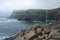 World famous Mulafossur waterfall falling from the cliff near Gasadalur village into the ocean in Faroe Islands . Misty, cloudy