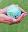 world globe hand holding grass background copy space