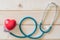 World health day campaign with red love heart  with cross bandage and medical doctor`s stethoscope, first aid concept