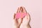 World hepatitis day. Adult hands holding donation liver on pink background. Awareness of prevention and treatment viral