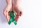 World kidney day, hands holding green ribbon awareness of kidney disease  white background