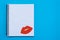 World Kiss Day. Red lips on a blank sheet of open notebook on a blue background