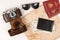 World map, two passports, money in a black leather wallet, an old film camera in a leather case and sunglasses on a white t
