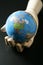 The world map in wood mannequin hand over black