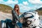 World Motorcyclist Day. A young caucasian woman in a leather jacket and sunglasses sitting on a motorbike. Road and
