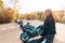 World Motorcyclist Day. A young pretty woman in a leather jacket, holding a motorcycle helmet in her hand. In the