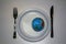 World on a plastic plate with plastic cuttlery. Plastic pollution concept