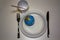 World on a plastic plate with plastic cuttlery, plastic up and a plastic straw. Plastic pollution concept