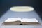 World Religion Day. An open book of the Holy Bible, with a glowing halo above it. Dark background. The concept of