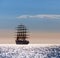 The world`s largest sailing ship leaves at sunset in the open sea