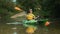 World Tourism Day. A happy Caucasian woman learning to rowing in a kayak. View from water surface. Real time. The