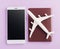 World Tourism Day, Top view flat lay of minimal toy model plane, airplane on passport and mobile smartphone blank screen