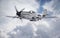 World War II era fighter flies among clouds and blue sky