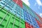 Worm`s eye view of 3d rendered colorful shipping containers stacked on one another making a wall that goes up in blue