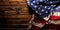 Worn American flag on dark wooden background