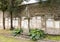 Worn ancient statue and wall plaques in the garden outside the Basilica of Sant\\\'Apollinare in Ravenna, Italy.