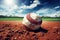 Worn baseball resting on the dirt of a sunny baseball field