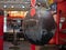 Worn, black leather wrecking ball style heavy bag hanging at a boxing gym