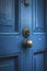 A worn blue door with a traditional doorknob.