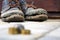 Worn boots with a lagging sole on a background of gray pavers and dark brown wood.