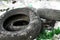Worn car tires are lying in the trash. Environmental pollution