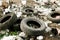 Worn car tires are lying in the trash. Environmental pollution