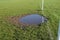 Worn football goalmouth with water