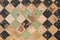 Worn green black and brown mosaic square tile flooring