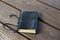 Worn leather bound black journal outdoors on table