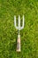 Worn metal and wooden hand fork on grass