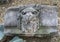 Worn old decorative stone lions head on the ground in Dallas, Texas.